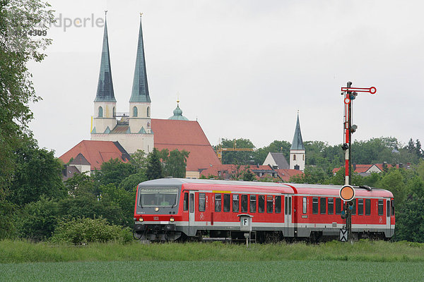 Personennahverkehr der Süd-Ost-Bayernbahn bei Altötting  im Hintergrund die Stiftspfarrkirche  Oberbayern  Bayern  Deutschland