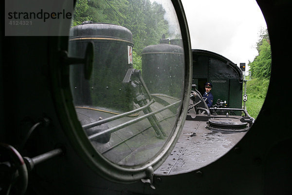 Blick aus einer historischen Dampflokomotive in Richtung Personenwagen und Schaffner