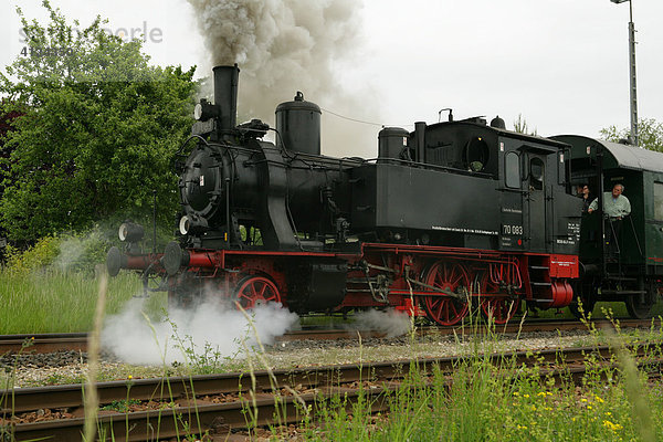 Historische Dampflokomotive zieht Personenwagen
