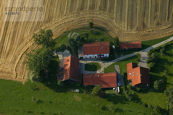 Bauernhof umgeben von abgeernteten Getreidefeldern und Wiesen  Niederbayern  Bayern  Deutschland