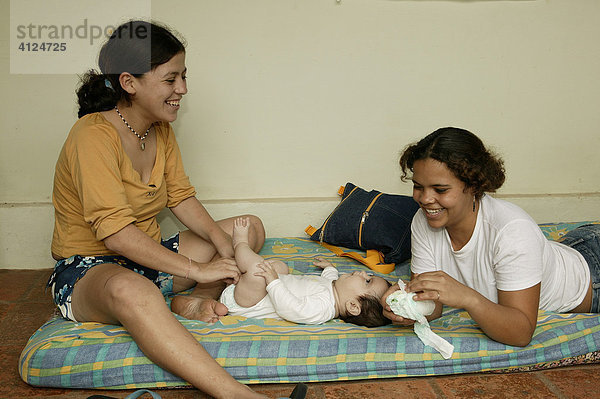 Zwei junge Frauen wickeln einen Säugling  Asuncion  Paraguay  Südamerika