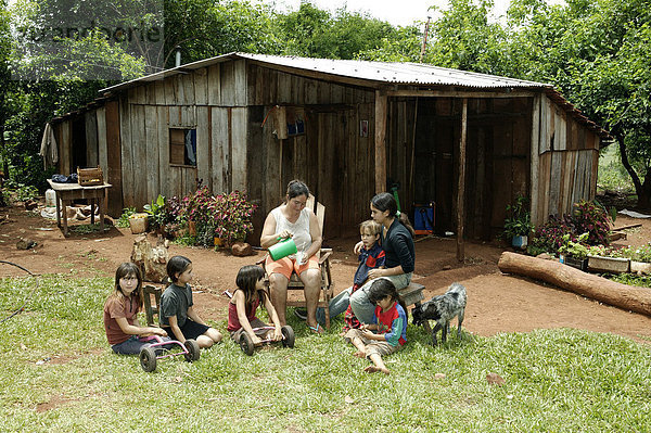 Eine Gruppe Frauen und Kinder machen Pause vor dem Haus  Paraguay  Südamerika