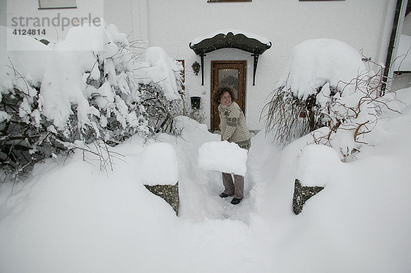Frau beim Schnee schaufeln  Oberbayern  Bayern  Deutschland  Europa