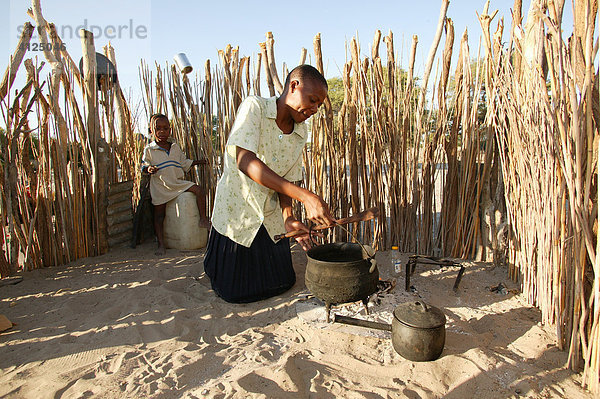 Eine Frau kocht im Kral  Sehitwa  Botswana  Afrika