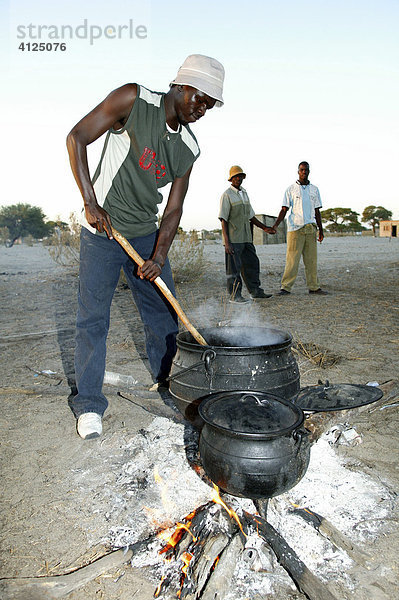 Männer kochen auf dem Dorfplatz  Sehitwa  Botswana  Afrika