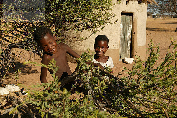 Zwei Jungen spielen mit einem Ast  Cattlepost Bothatogo  Botswana  Afrika