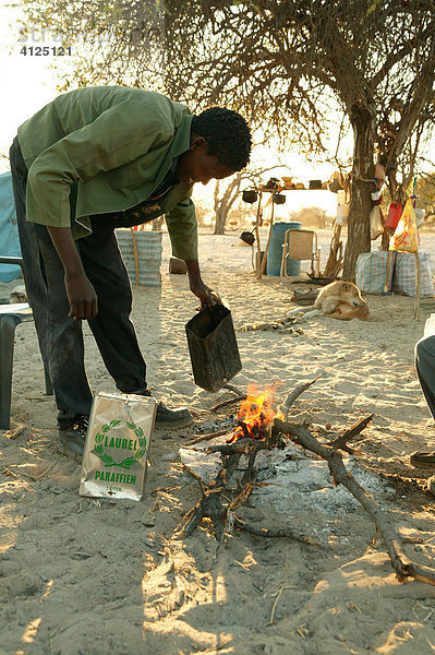 Mann macht Feuer und bereitet Frühstück  Cattlepost Bothatoga  Botswana  Afrika