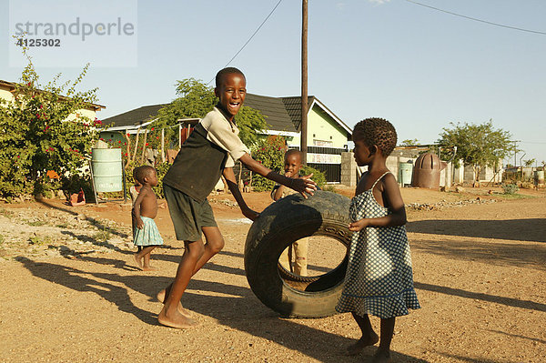 Junge spielt auf der Straße mit einem altem Autoreifen  Sehitwa  Botswana  Afrika