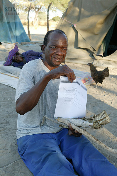 Patient eines traditionellen Heilers zeigt sein Rezept mit der Dosierung seiner Heilpflanzen vor  Sehitwa  Botswana  Afrika