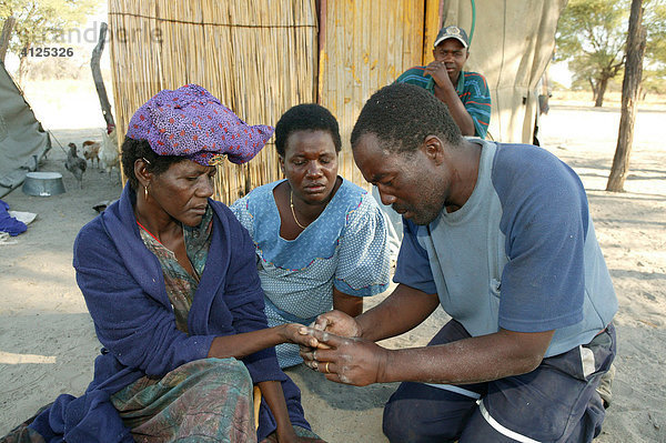 Hand-Diagnose  traditioneller Heiler mit Kranken  Sehitwa  Botswana  Afrika