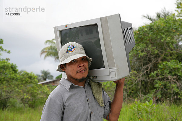 Mann bring einen Fernsehapparat nach Hause  Amerindians vom Stamm der Arawaks  Santa Mission  Guyana  Südamerika