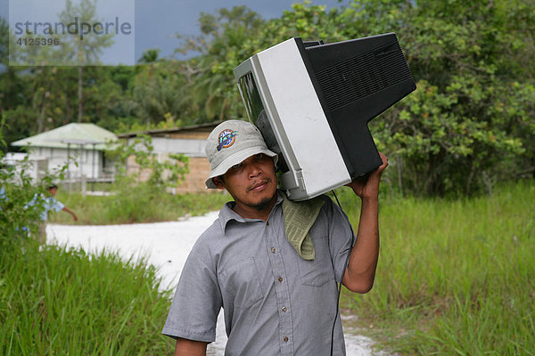 Mann bringt einen Fernsehapparat nach Hause  Amerindians vom Stamm der Arawaks  Santa Mission  Guyana  Südamerika