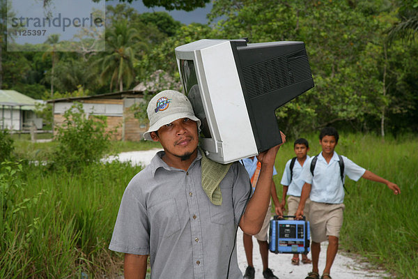 Mann bringt einen Fernsehapparat nach Hause  Amerindians vom Stamm der Arawaks  Santa Mission  Guyana  Südamerika