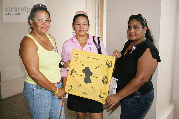 Drei Frauen verschiedener Ethnien mit einer Karte Guyanas  während einer Demonstration gegen Gewalt gegenüber Frauen  Georgetown  Guyana  Südamerika