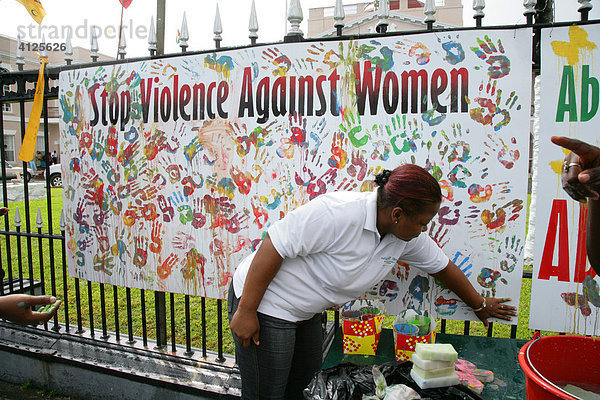 Junge Frau während einer Demonstration gegen Gewalt gegenüber Frauen  bunte Handabdrücke als Symbol für verschiedene Ethnien  Georgetown  Guyana  Südamerika