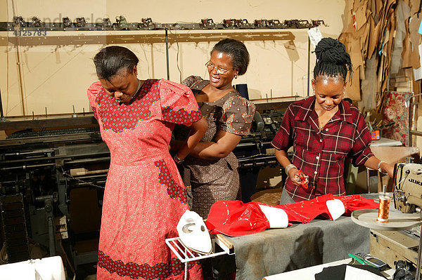 Frauen probieren ein Kleid an  Schneiderei einer HIV /AIDS Hilfsorganisation  Gaborone  Botswana  Afrika