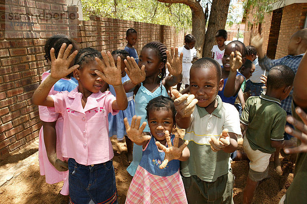 Kinder zeigen ihre sandigen Hände  im Kindergarten  Gaborone  Botswana  Afrika