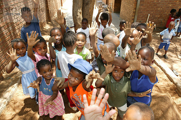 Kinder zeigen ihre sandigen Hände  im Kindergarten  Gaborone  Botswana  Afrika