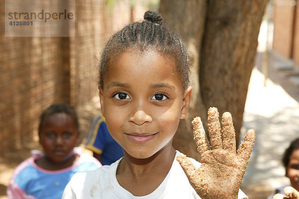 Mädchen zeigt ihre sandige Hand  im Kindergarten  Gaborone  Botswana  Afrika