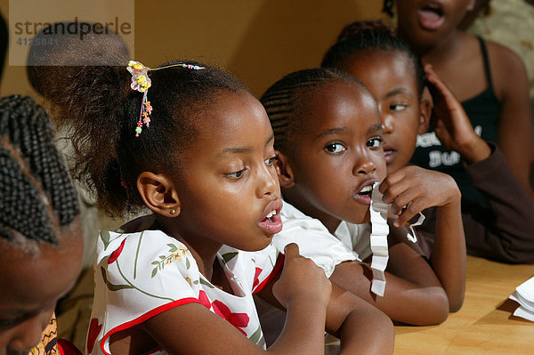 Kinder sitzen am Tisch  Francistown  Botswana  Afrika