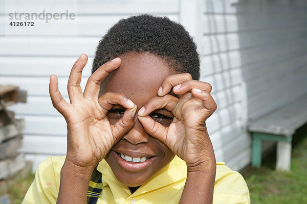 Mädchen schaut durch eine Fingerbrille  Waisenhaus Ursulinen Konvent  Georgetown  Guyana  Südamerika