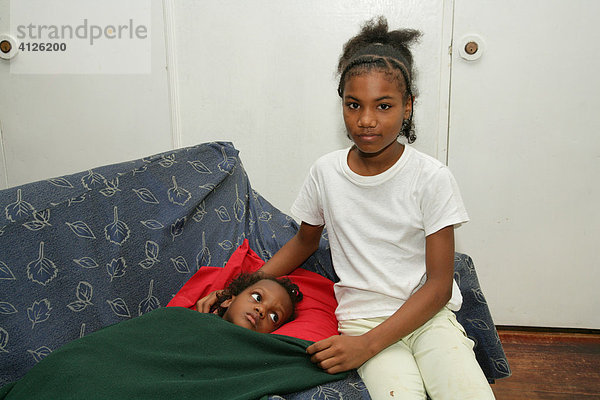 Mädchen sitzt am Krankenlager eines kleinen Kindes  Alltag im Waisenhaus Ursulinen Konvent  Georgetown  Guyana  Südamerika