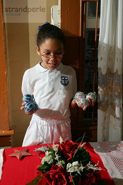 Mädchen mit Weihnachtskugeln hilft beim Dekorieren  Georgetown  Guyana  Südamerika