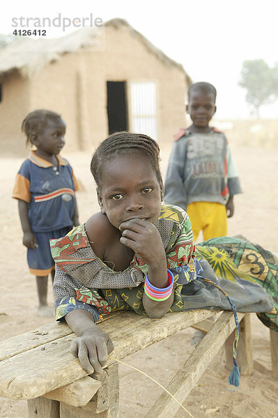 Mädchen liegt auf einer Bank  Dorfstraße  Sahelzone  Kamerun  Afrika