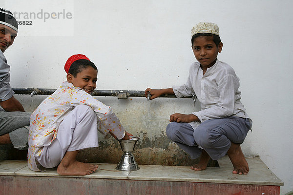 Jungen waschen Ritualgegenstände eines Schreins  Bareilly  Uttar Pradesh  Indien  Asien