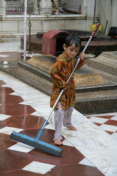 Junge reinigt den sufistischen Schrein  Bareilly  Uttar Pradesh  Indien  Asien