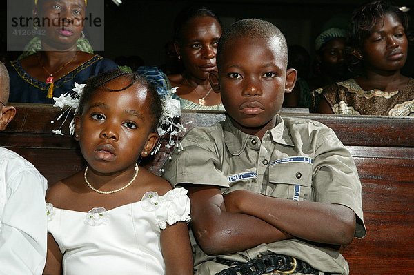 Mädchen und Junge sitzen auf einer Kirchenbank  Douala  Kamerun  Afrika
