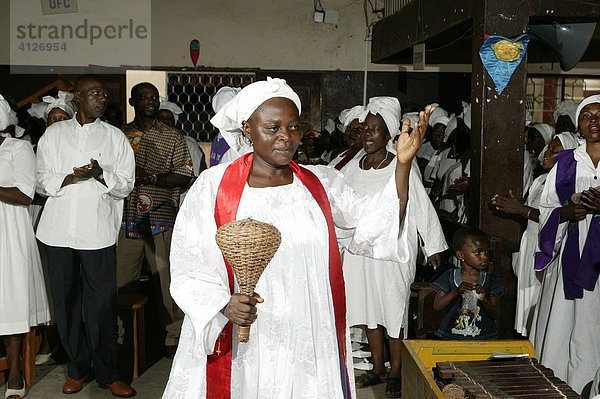 Betschwester musiziert mit Rassel  Gottesdienst  Douala  Kamerun  Afrika