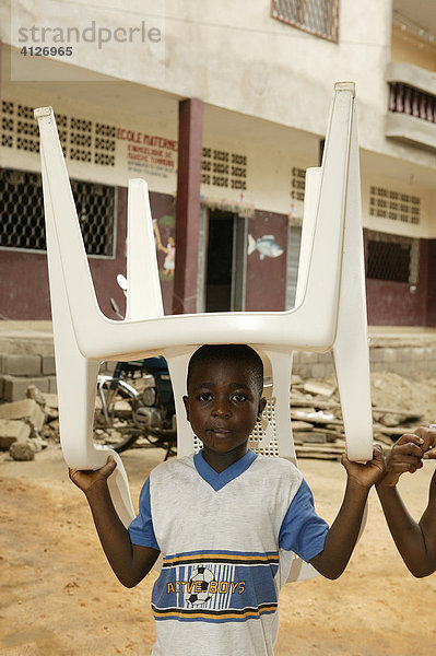 Junge trägt Stuhl auf dem Kopf  Douala  Kamerun  Afrika