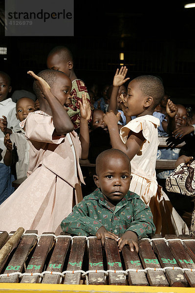 Zwei Mädchen tanzen  Junge steht am Marimbaphon  Gottesdienst  Douala  Kamerun  Afrika