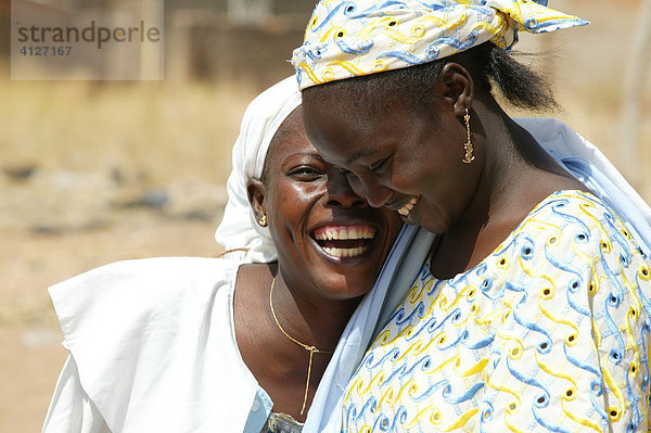 Zwei lachende Frauen während eines Gottesdienstes  Garoua  Kamerun  Afrika