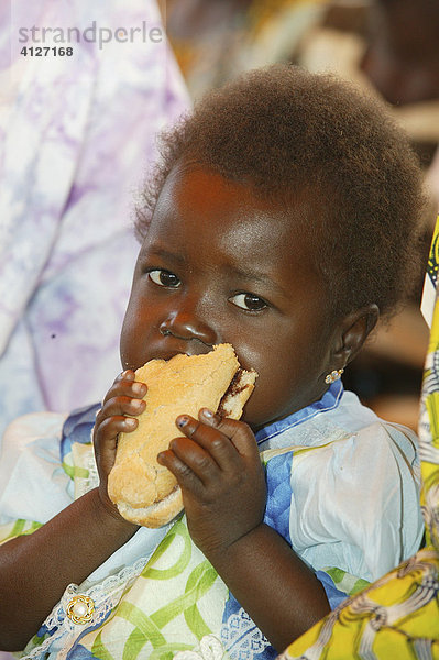 Kleinkind isst Brot  Gemeinschaftsessen nach einem Gottesdienst  Garoua  Kamerun  Afrika