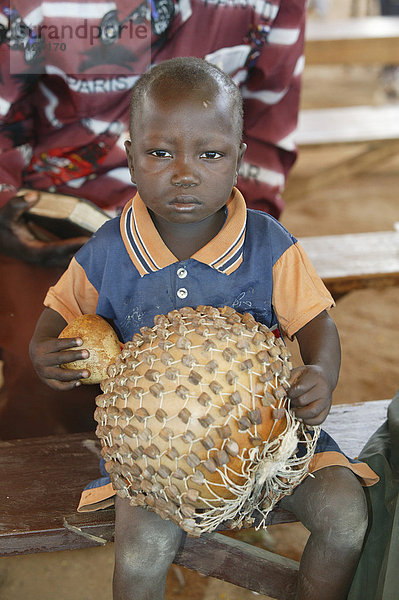 Junge mit Kürbis-Rassel während eines Gottesdienstes  Garoua  Kamerun  Afrika
