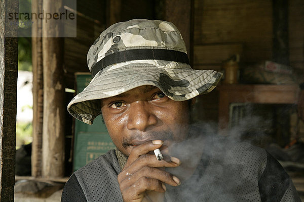 Rauchender junger Mann  Dorf Mindre  Papua Neuguinea  Melanesien  Kontinent Australien