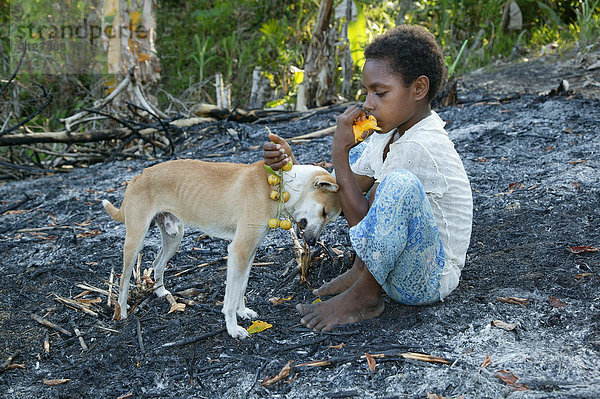 Junge mit Hund  isst Mangos und Apfelsinen  Heldsbach  Papua Neuguinea  Melanesien  Kontinent Australien