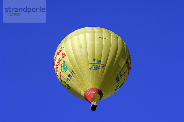 Schwebender gelber Heißluftballon vor blauem Himmel  Montgolfiade  Bad Wiessee  Oberbayern  Bayern  Deutschland