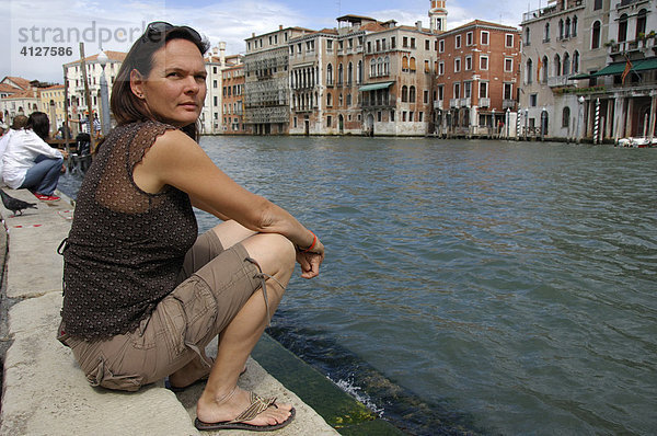 Frau sitzt auf Steinstufen am Canale Grande  Venedig  Venezien  Italien  Europa