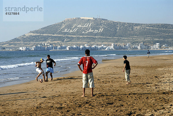 Freizeitkicker am Strand von Agadir  Berg mit dem Schriftzug Allah  el-Watan  el-Malik (Gott  die Heimat  der König)  Marokko  Afrika