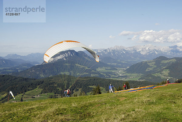 Gleitschirmflieger beim Starten am Marchbach Joch Wildschönau  Blick auf Inntal und Wilden Kaiser  Tirol Österreich