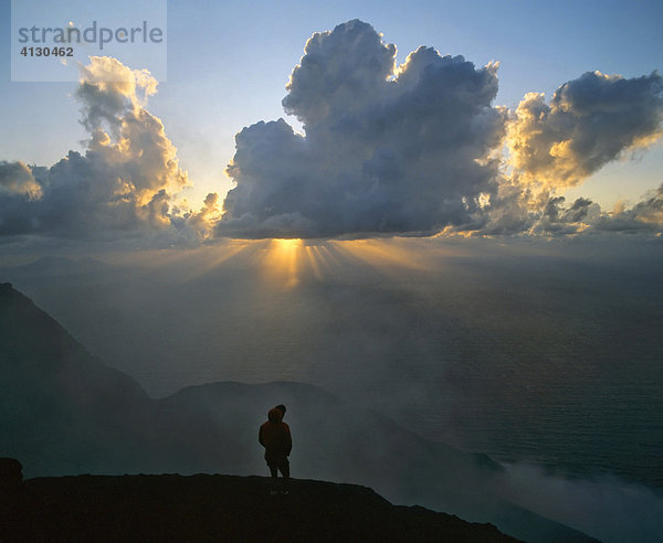 Gipfel des Stromboli  Mann im Gegenlicht  Sonnenstrahlen  Strahlenkranz  Liparische Inseln  Sizilien  Italien