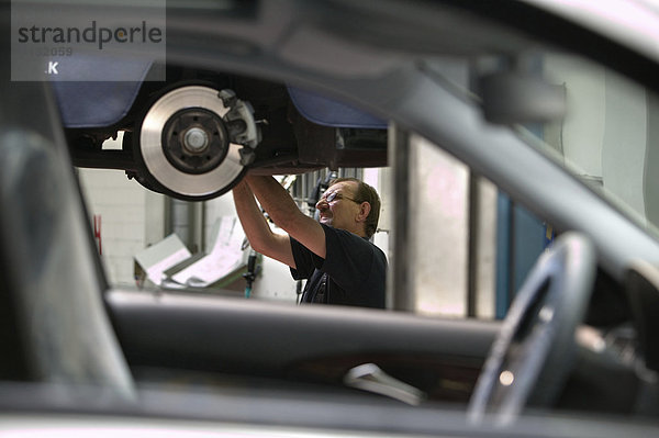 Offenburg  DEU  07.06.2006: Werkstatt der S+G Automobil AG  ein Deutschland weit aktiver Daimler Chrysler A-Vertragshaendler. Mechaniker Leonhard Musiol arbeitet an den Scheibenbremsen eines Mercedes.