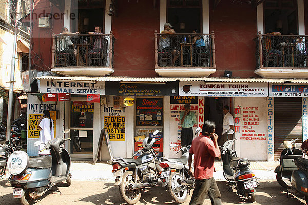 Tourist auf dem Balkon eines Restaurants in einem alten portugiesischen Gebäude schauen auf die Straße  Panaji  Panjim. Goa  Indien