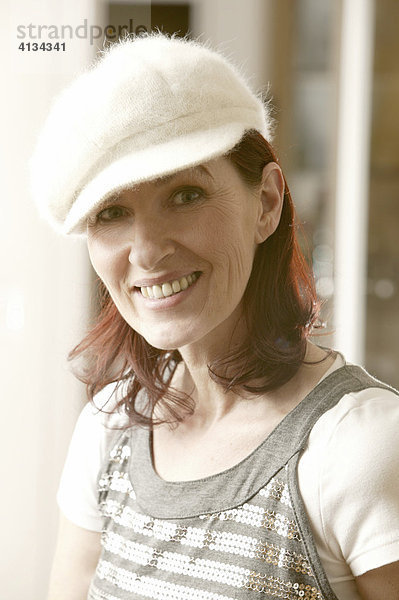 Frau im mittleren Alter mit weißer Mütze  Portrait  lacht