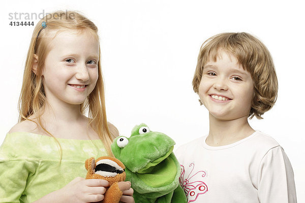Zwei 8-jährige Mädchen mit Kuscheltieren