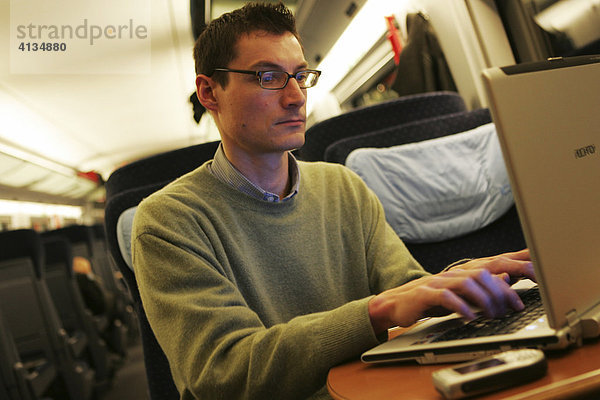 DEU Bundesrepublik Deutschland : Mann arbeitet an seinem Laptop Computer im Grossraum Abteil eines ICE3 Zuges