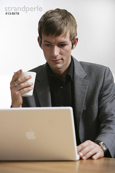 DEU  Bundesrepublik Deutschland : Junger Mann arbeitet an einen Laptop Computer  Apple.